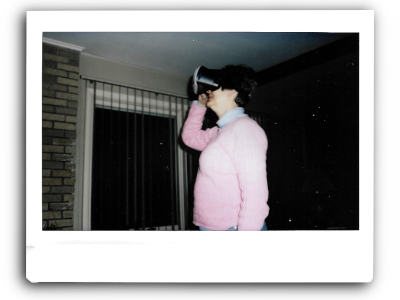 an instant picture of my mom in a pink sweatshirt looking up and wearing vr goggles