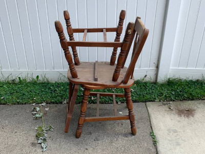 two wooden chairs stacked on top of each other, seat to seat