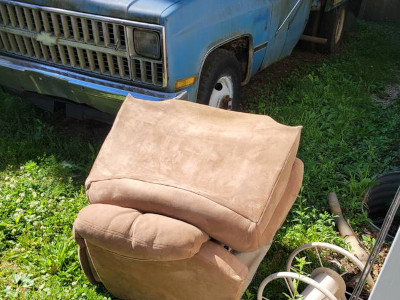 tan easy chair in front of a blue chevy truck