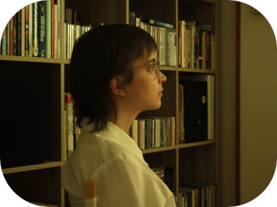 madi in a white dress shirt sitting in front of our bookshelf in the living room