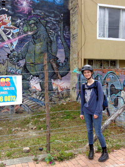 madi standing in front of a godzilla mural