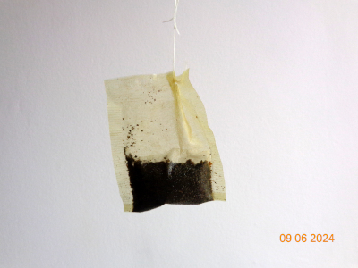 a tea bag against a white wall